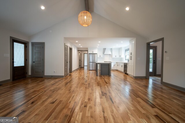 215 Holman Ave, Athens, GA 30606 - unfurnished living room featuring high vaulted ceiling, wood finished floors, recessed lighting, baseboards, and beam ceiling