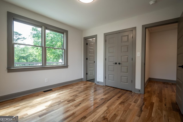 215 Holman Ave, Athens, GA 30606 - unfurnished bedroom with wood finished floors, baseboards, and a closet