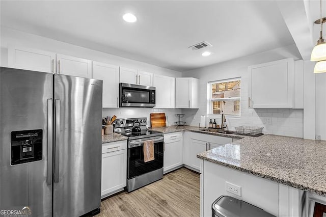 2912 Palm Dr, East Point, GA 30344 - kitchen featuring stainless steel appliances, a sink, white cabinets, light stone counters, and recessed lighting