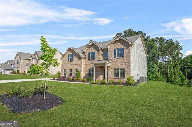 361 Traditions Ln, Hampton, GA 30228 - craftsman-style home with cooling unit, a front yard, and brick siding