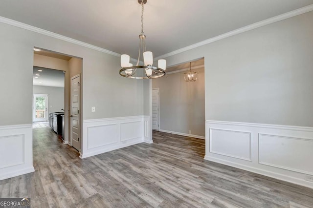 7760 Hansel Ln, Lithonia, GA 30058 - spare room featuring a chandelier, wood finished floors, a decorative wall, and a wainscoted wall