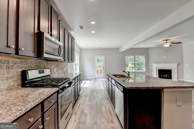 7760 Hansel Ln, Lithonia, GA 30058 - kitchen with stainless steel appliances, a sink, tasteful backsplash, light wood-style floors, and baseboards