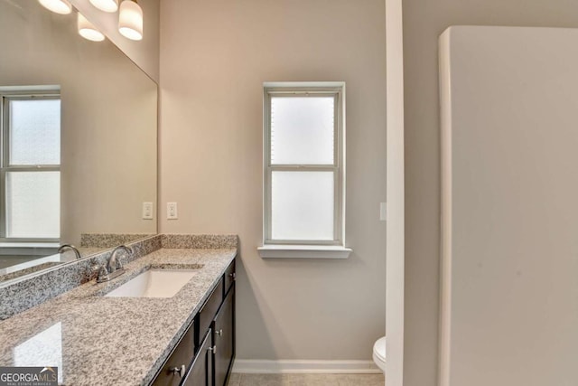 7760 Hansel Ln, Lithonia, GA 30058 - bathroom with toilet, vanity, healthy amount of natural light, and baseboards