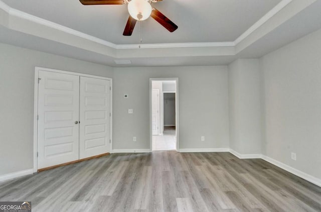 7760 Hansel Ln, Lithonia, GA 30058 - unfurnished bedroom with crown molding, wood finished floors, a tray ceiling, baseboards, and a closet