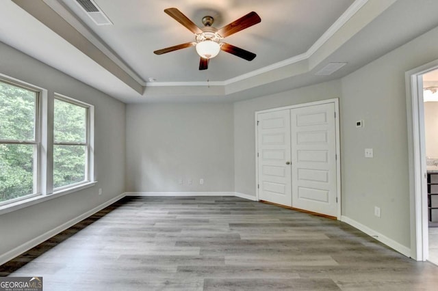 7760 Hansel Ln, Lithonia, GA 30058 - unfurnished bedroom with a tray ceiling, multiple windows, crown molding, and wood finished floors