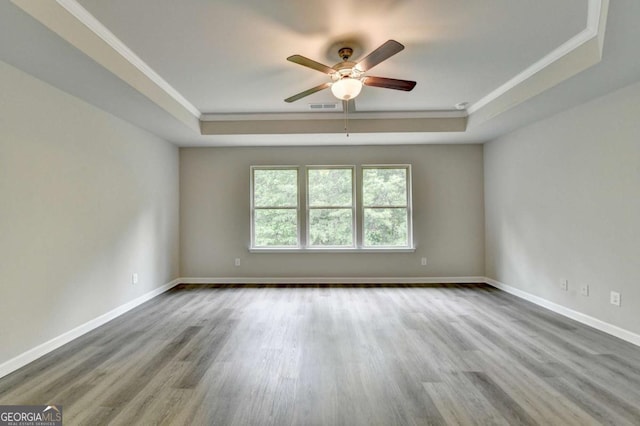 7760 Hansel Ln, Lithonia, GA 30058 - empty room featuring a raised ceiling, ceiling fan, ornamental molding, wood finished floors, and baseboards