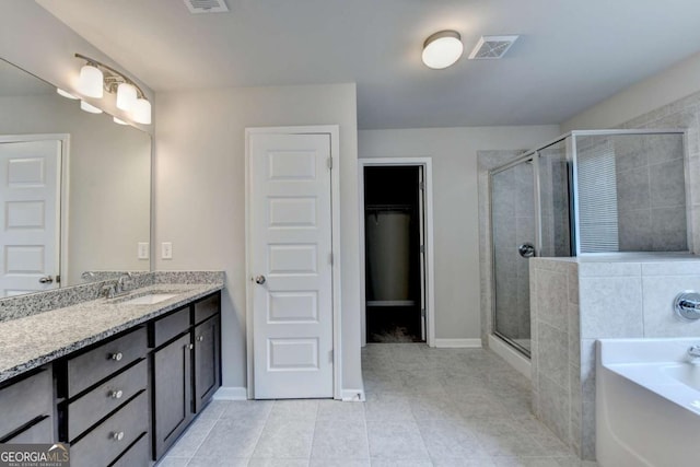 7760 Hansel Ln, Lithonia, GA 30058 - bathroom featuring vanity, a stall shower, a bath, tile patterned floors, and a spacious closet