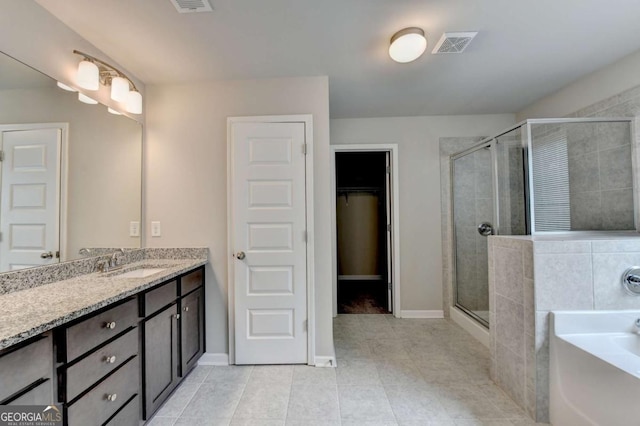 7760 Hansel Ln, Lithonia, GA 30058 - bathroom featuring vanity, a stall shower, a bath, tile patterned floors, and a spacious closet