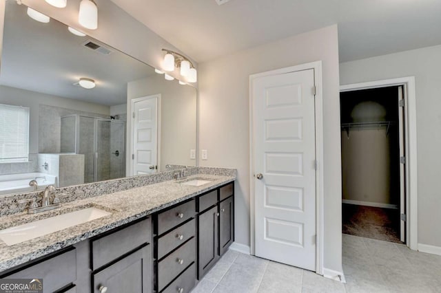 7760 Hansel Ln, Lithonia, GA 30058 - bathroom featuring a stall shower, double vanity, a bath, tile patterned flooring, and baseboards