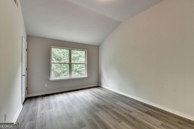 7760 Hansel Ln, Lithonia, GA 30058 - unfurnished room with wood finished floors, vaulted ceiling, and baseboards