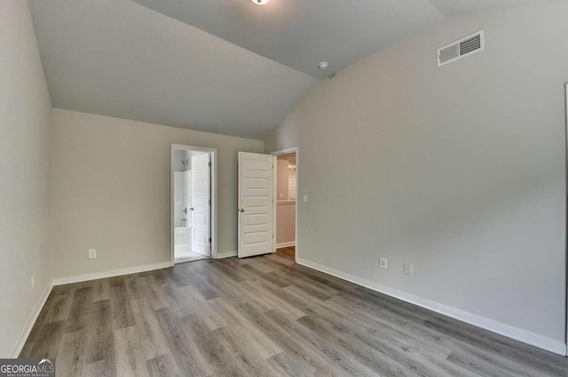 7760 Hansel Ln, Lithonia, GA 30058 - unfurnished bedroom featuring lofted ceiling, wood finished floors, baseboards, and connected bathroom