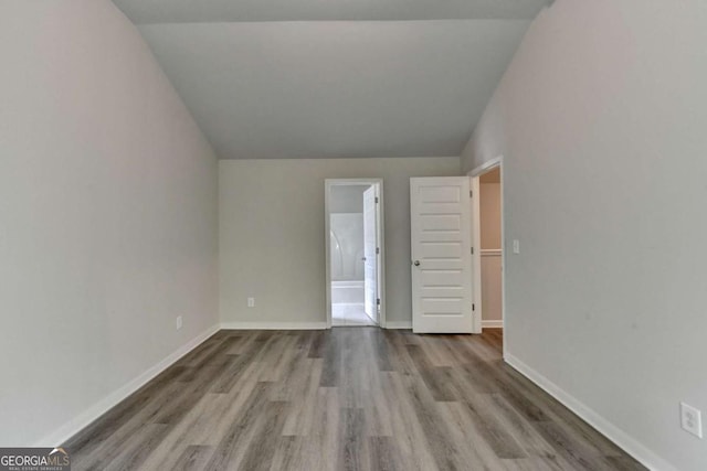 7760 Hansel Ln, Lithonia, GA 30058 - unfurnished bedroom with vaulted ceiling, wood finished floors, and baseboards