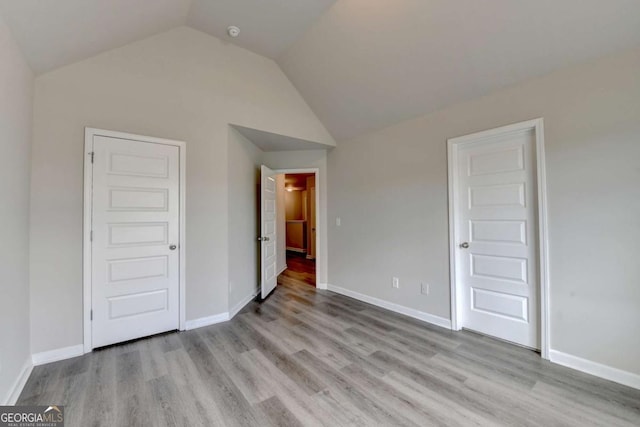 7760 Hansel Ln, Lithonia, GA 30058 - unfurnished bedroom with light wood-style floors, vaulted ceiling, and baseboards
