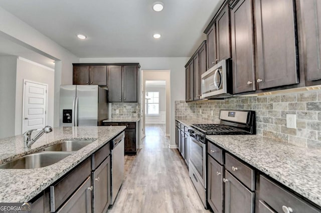 7760 Hansel Ln, Lithonia, GA 30058 - kitchen with stainless steel appliances, a sink, dark brown cabinets, light stone counters, and backsplash