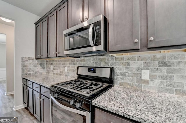 7760 Hansel Ln, Lithonia, GA 30058 - kitchen featuring stainless steel appliances, light stone countertops, tasteful backsplash, and dark brown cabinets