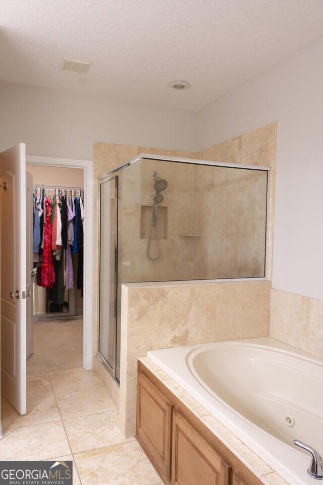276 Laurel Landing Blvd, Kingsland, GA 31548 - full bathroom with a bath, a shower stall, a textured ceiling, and a walk in closet