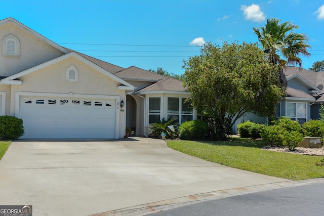 276 Laurel Landing Blvd, Kingsland, GA 31548 - view of front of house featuring an attached garage, concrete driveway, a front lawn, and stucco siding