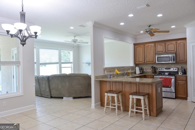 276 Laurel Landing Blvd, Kingsland, GA 31548 - kitchen with stainless steel appliances, a peninsula, ceiling fan, crown molding, and a breakfast bar