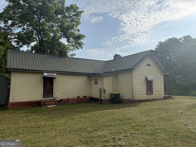 7779 Mill St SW, Cave Spring, GA 30124 - rear view of house with a chimney, entry steps, a lawn, and metal roof