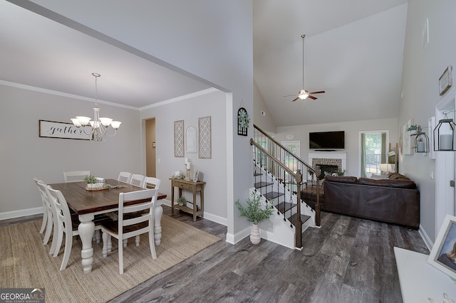 433 Wilson Dr, Mcdonough, GA 30252 - dining room featuring dark wood-type flooring, a chandelier, a ceiling fan, a brick fireplace, and high vaulted ceiling