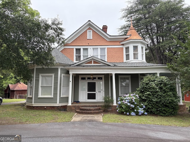 435 Jackson St, Locust Grove, GA 30248 - victorian-style house with a chimney, a shingled roof, and a porch