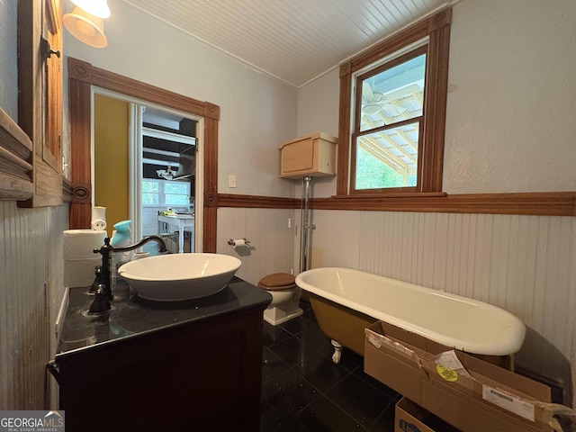 435 Jackson St, Locust Grove, GA 30248 - bathroom with wainscoting, a soaking tub, vanity, and healthy amount of natural light