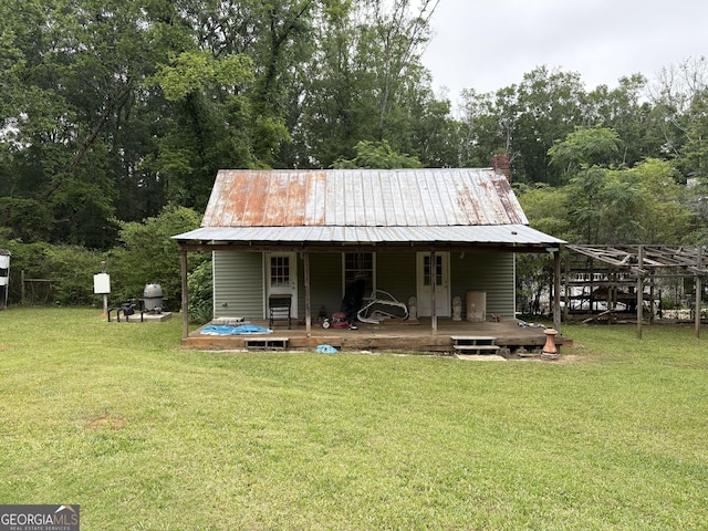 435 Jackson St, Locust Grove, GA 30248 - rear view of property with a lawn, covered porch, and metal roof