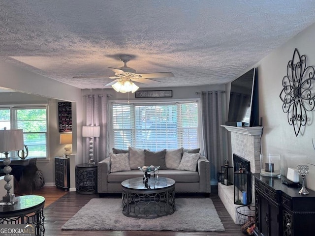 107 Woodhaven Dr, Stockbridge, GA 30281 - living area with healthy amount of natural light, a textured ceiling, wood finished floors, a ceiling fan, and a brick fireplace