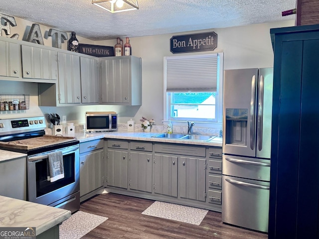 107 Woodhaven Dr, Stockbridge, GA 30281 - kitchen featuring stainless steel appliances, gray cabinets, a sink, a textured ceiling, and light countertops