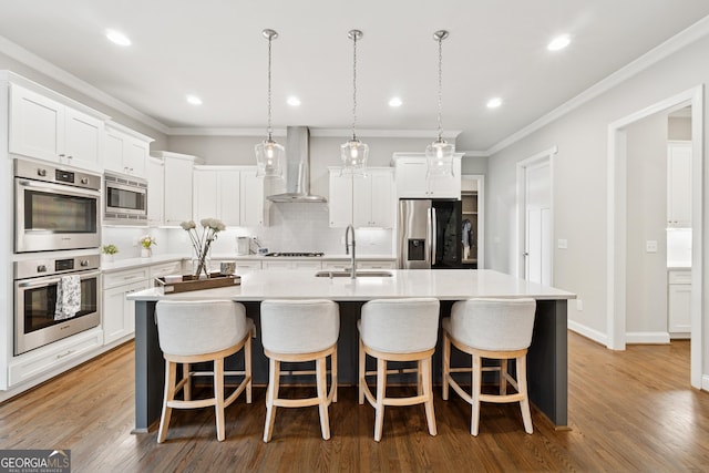 3998 Commodore Dr, Atlanta, GA 30341 - kitchen with stainless steel appliances, wall chimney range hood, a sink, decorative backsplash, and a large island with sink