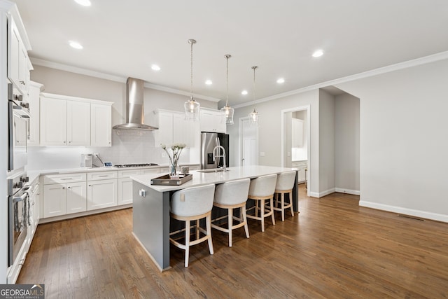 3998 Commodore Dr, Atlanta, GA 30341 - kitchen with wall chimney exhaust hood, stainless steel appliances, an island with sink, backsplash, and a breakfast bar area
