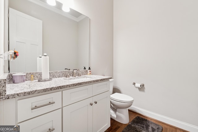 3998 Commodore Dr, Atlanta, GA 30341 - half bath featuring toilet, wood finished floors, vanity, baseboards, and crown molding