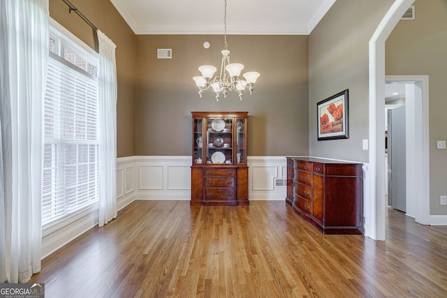 1621 White Oak Cv, Loganville, GA 30052 - dining room with light wood finished floors, a chandelier, ornamental molding, arched walkways, and a high ceiling