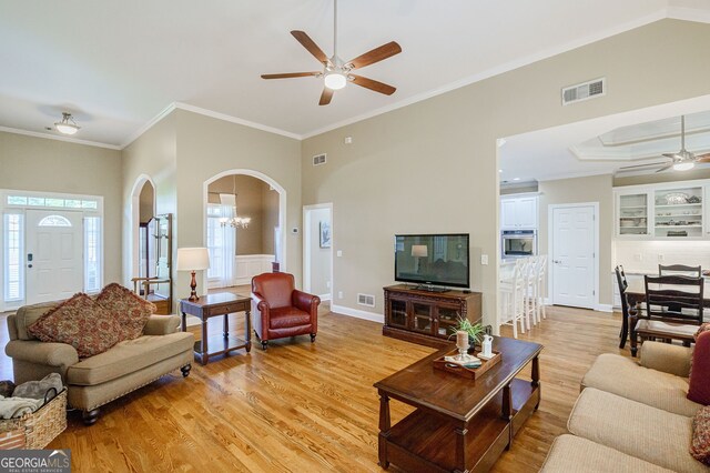 1621 White Oak Cv, Loganville, GA 30052 - living area featuring a ceiling fan, arched walkways, light wood finished floors, crown molding, and baseboards