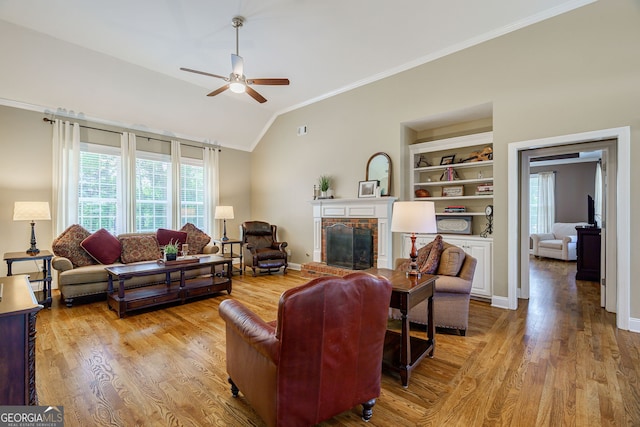 1621 White Oak Cv, Loganville, GA 30052 - living area featuring ornamental molding, healthy amount of natural light, a ceiling fan, a fireplace, and vaulted ceiling