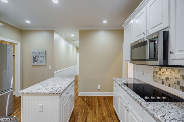 1621 White Oak Cv, Loganville, GA 30052 - kitchen with appliances with stainless steel finishes, tasteful backsplash, dark wood-style floors, white cabinets, and ornamental molding