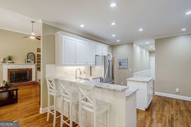 1621 White Oak Cv, Loganville, GA 30052 - kitchen with high end refrigerator, a center island, a ceiling fan, crown molding, and tasteful backsplash