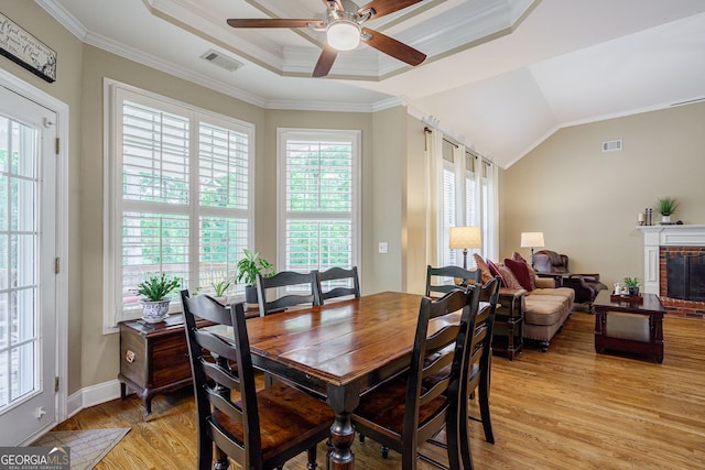 1621 White Oak Cv, Loganville, GA 30052 - dining space with light wood-style floors, ceiling fan, ornamental molding, a fireplace, and a tray ceiling