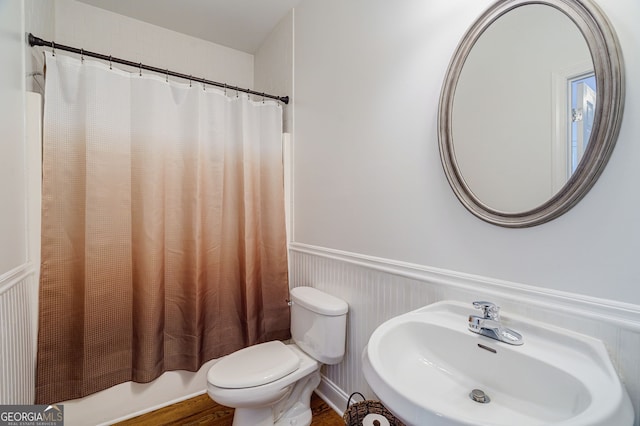 1621 White Oak Cv, Loganville, GA 30052 - bathroom with a sink, toilet, wainscoting, shower / bath combo, and wood finished floors
