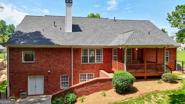 1621 White Oak Cv, Loganville, GA 30052 - back of house featuring roof with shingles, a chimney, brick siding, and a wooden deck