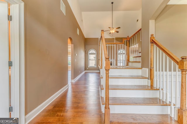 100 Harmony Ct, Dallas, GA 30157 - stairway featuring wood finished floors, arched walkways, ceiling fan, a towering ceiling, and baseboards