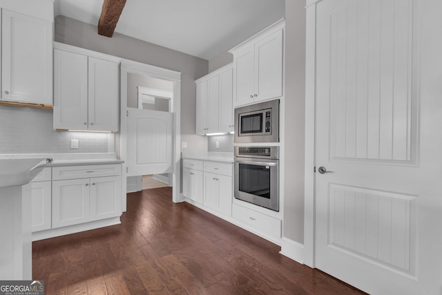 406 Vanderbilt Pkwy, Newnan, GA 30265 - kitchen featuring stainless steel appliances, dark wood-type flooring, white cabinets, decorative backsplash, and light countertops