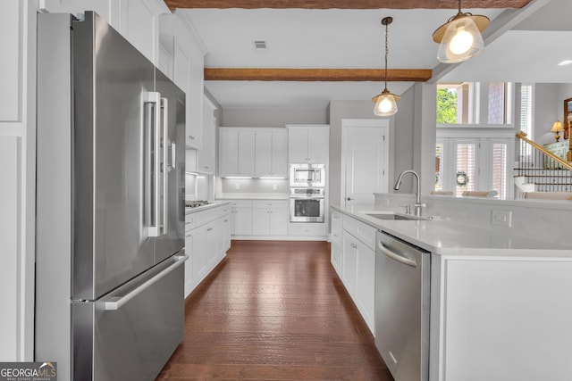 406 Vanderbilt Pkwy, Newnan, GA 30265 - kitchen featuring appliances with stainless steel finishes, a sink, beam ceiling, dark wood-style floors, and pendant lighting