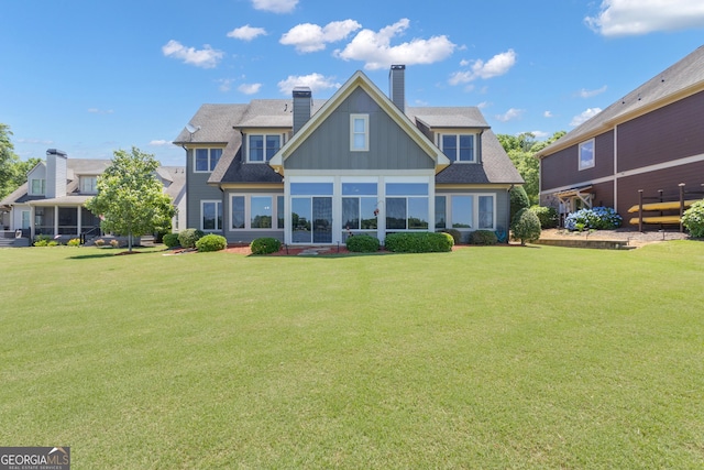 406 Vanderbilt Pkwy, Newnan, GA 30265 - rear view of property with a chimney, board and batten siding, and a lawn