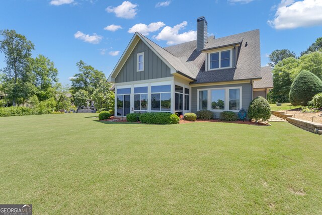 406 Vanderbilt Pkwy, Newnan, GA 30265 - back of house with board and batten siding, a lawn, a chimney, and roof with shingles