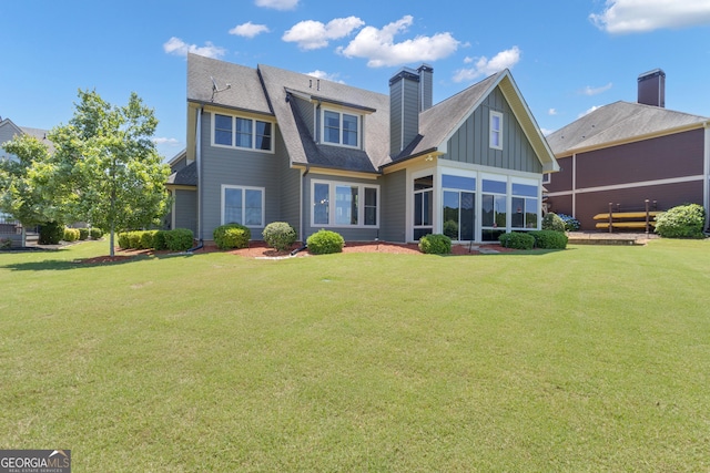 406 Vanderbilt Pkwy, Newnan, GA 30265 - rear view of property featuring board and batten siding, a lawn, a chimney, and a shingled roof