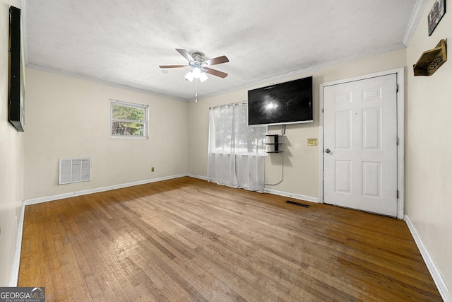 14301 Veterans Memorial Hwy, Villa Rica, GA 30180 - unfurnished living room featuring ceiling fan, wood finished floors, baseboards, ornamental molding, and a textured ceiling