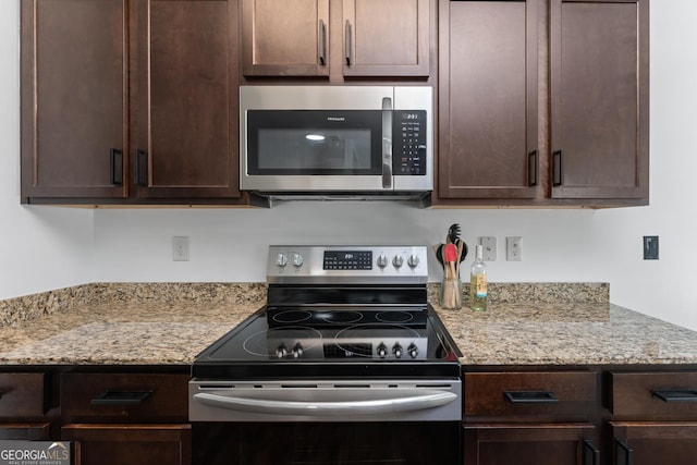 3993 Makeover Ct, South Fulton, GA 30349 - kitchen featuring appliances with stainless steel finishes, dark brown cabinetry, and light stone countertops