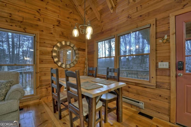 355 Cohutta Mountain Rd, Cherry Log, GA 30522 - dining space with wood walls, a baseboard heating unit, a chandelier, light wood-type flooring, and healthy amount of natural light