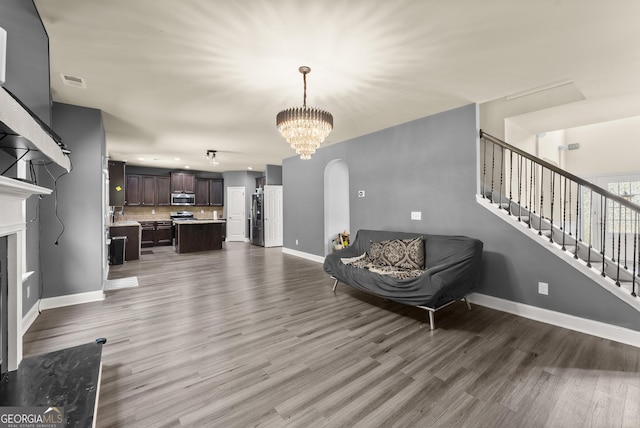 240 Somerset Dr, Dallas, GA 30132 - living room featuring wood finished floors, a chandelier, baseboards, stairs, and arched walkways